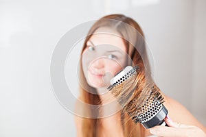 Young beautiful woman is doing hairstyle