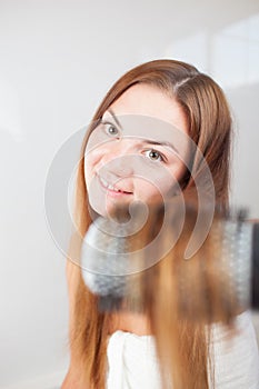 Young beautiful woman is doing hairstyle