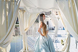 Young beautiful woman in dress standing on pier