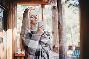 Young beautiful woman drinking cocoa in a wooden coutry house