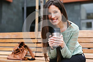 Young beautiful woman drinking coffee in outdoors.