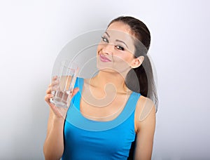 Young beautiful woman drinking fresh pure water from glass on bl