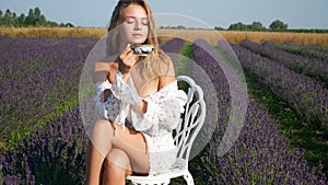 Young Beautiful Woman drinking tea In Lavender Field On Summer Day