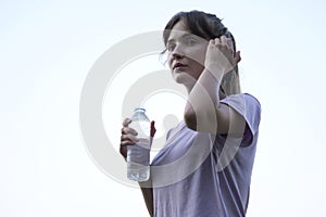 Young beautiful woman drinking water in park.