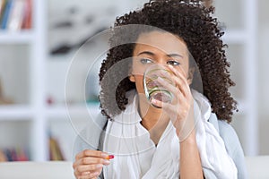 Young beautiful woman drinks water from glass