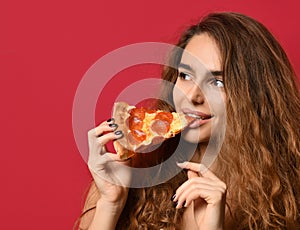 Young beautiful woman eat slice of pepperoni pizza with closed eyes smiling on red pink