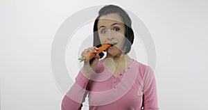 Young beautiful woman eating big carrot. Healthy nutrition