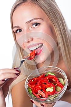 Young beautiful woman eats vegetable salad. Healthy eating. To be in shape.