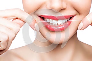 Young beautiful woman is engaged in cleaning teeth. Beautiful smile healthy white teeth. A girl holds a dental floss