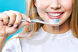 Young beautiful woman is engaged in cleaning teeth. Beautiful smile healthy white teeth. A girl holds a toothbrush. The