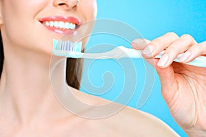 Young beautiful woman is engaged in cleaning teeth. Beautiful smile healthy white teeth. A girl holds a toothbrush. The