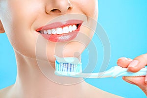 Young beautiful woman is engaged in cleaning teeth. Beautiful smile healthy white teeth. A girl holds a toothbrush. The