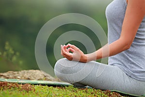 Young beautiful woman is engaged in hatha yoga in the morning misty mountains