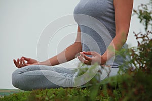 Young beautiful woman is engaged in hatha yoga in the morning misty mountains