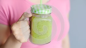 Young beautiful woman enjoying a healthy raw fruit vegetable smoothie