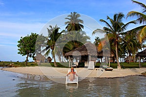 Young beautiful woman enjoying her time and resting close to the sea in the private beach of Yandup Island lodge in Panama.