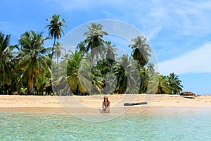 Young beautiful woman enjoying her time and resting close to the sea in the southern beach of Pelicano Island, Panama.