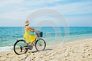 Young beautiful woman enjoying the sea view with her bicycle