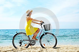 Young beautiful woman enjoying the sea view with her bicycle