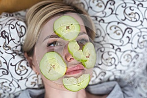 Young beautiful woman with Face pack and fresh cucumber slices on her eyes. Homemade Mud Facial Mask at Home. Multani