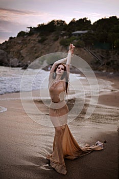 Young beautiful woman fallen angel stands on sea beach enjoy nature. costume bird white wings.