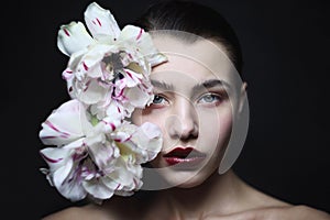 Young beautiful woman with fancy makeup and white tulips, selective focus