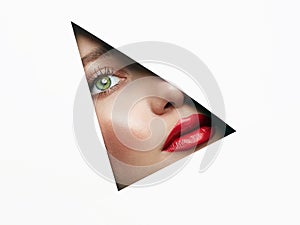 Young beautiful woman. female face with makeup into paper hole