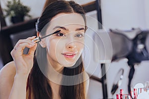 Young beautiful woman filming video about eye mascara