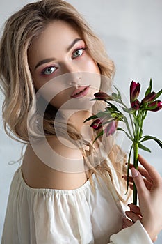a young beautiful woman with a flower in her hands. Fashion portrait close-up