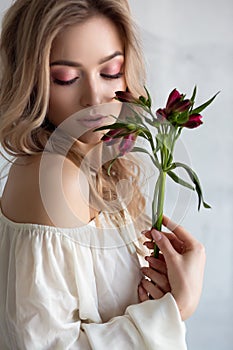 a young beautiful woman with a flower in her hands. Fashion portrait close-up