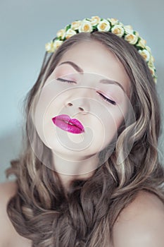 Young beautiful woman with flowers in hair and blue eyes