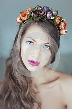 Young beautiful woman with flowers in hair and blue eyes