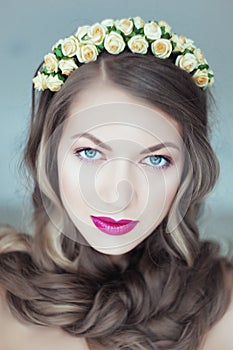 Young beautiful woman with flowers in hair and blue eyes
