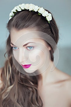 Young beautiful woman with flowers in hair and blue eyes