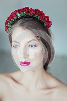 Young beautiful woman with flowers in hair and blue eyes