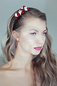 Young beautiful woman with flowers in hair and blue eyes