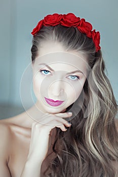 Young beautiful woman with flowers in hair and blue eyes