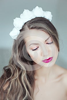 Young beautiful woman with flowers in hair and blue eyes