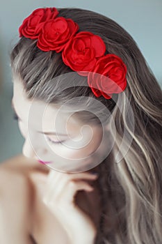 Young beautiful woman with flowers in hair and blue eyes