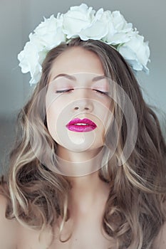 Young beautiful woman with flowers in hair and blue eyes