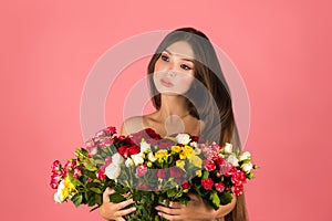 Young beautiful woman with flowers isolated on pink