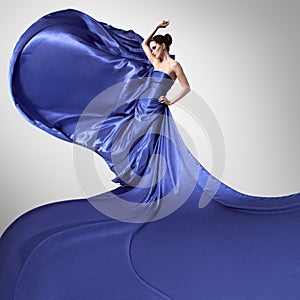 Young beautiful woman in fluttering blue dress.