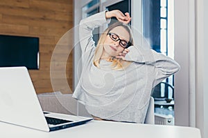 Young beautiful woman freelancer tired working at night on a laptop, completes work late