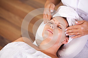 Young beautiful woman getting facial massage