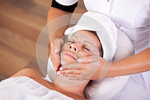 Young beautiful woman getting facial massage