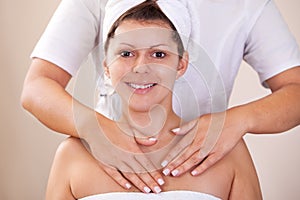 Young beautiful woman getting shoulders massage