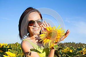 Young beautiful woman girl on background of sunflower field