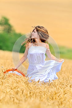 Young beautiful woman in golden wheat field
