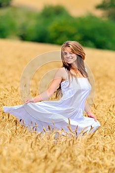 Young beautiful woman in golden wheat field