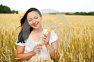 Young beautiful woman in golden wheat field. concept of summer, freedom, warmth, harvest, agriculture